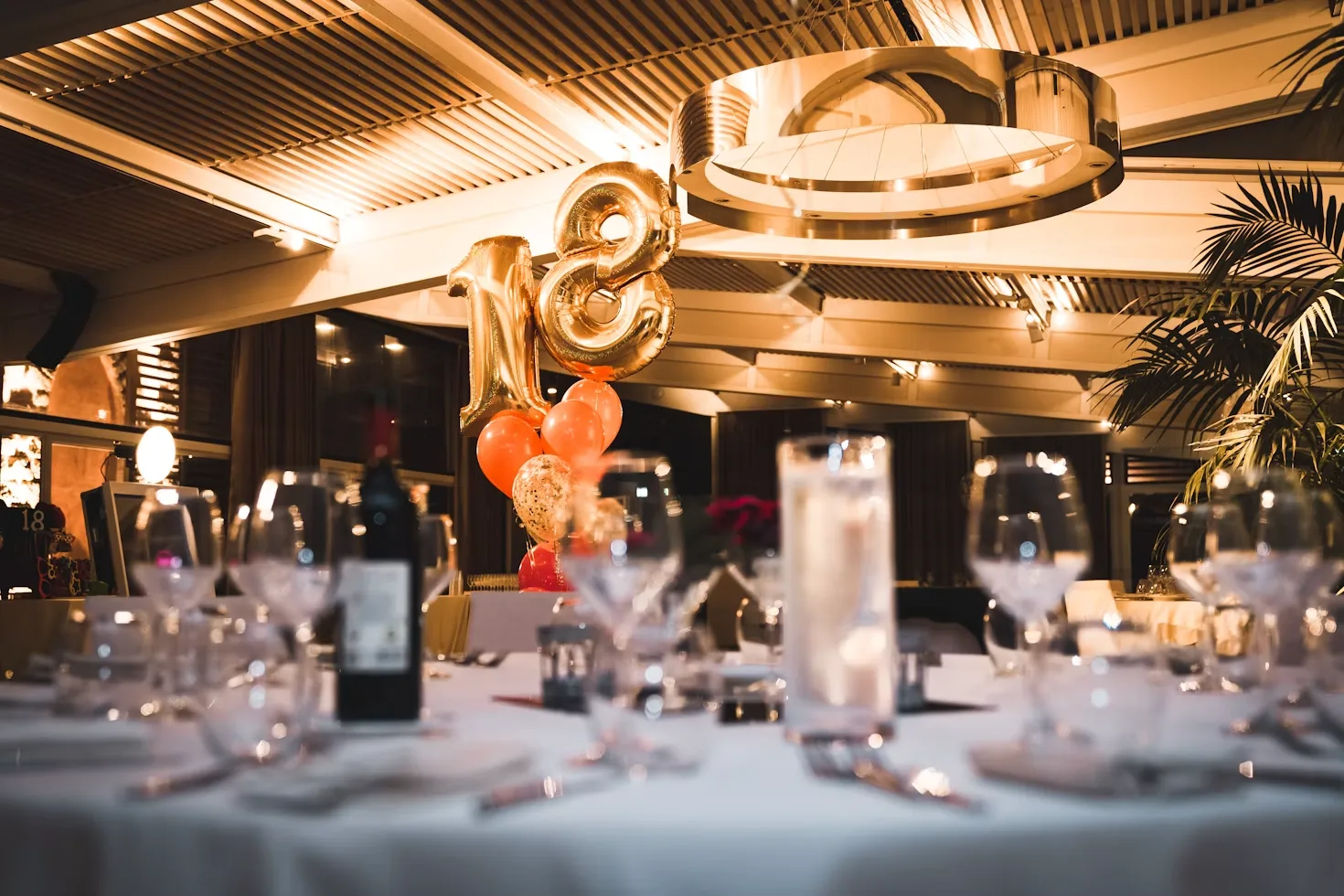 Private eighteenth birthday party venue with gold balloons and elegant table settings