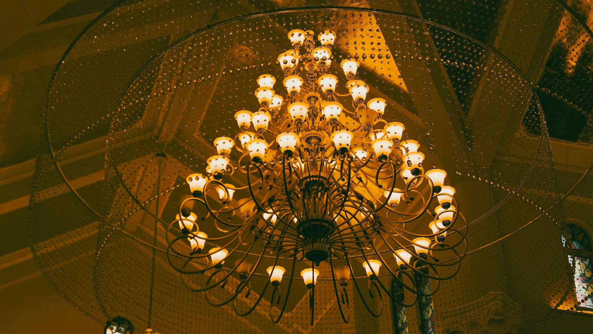 An illuminated chandelier above an evening event