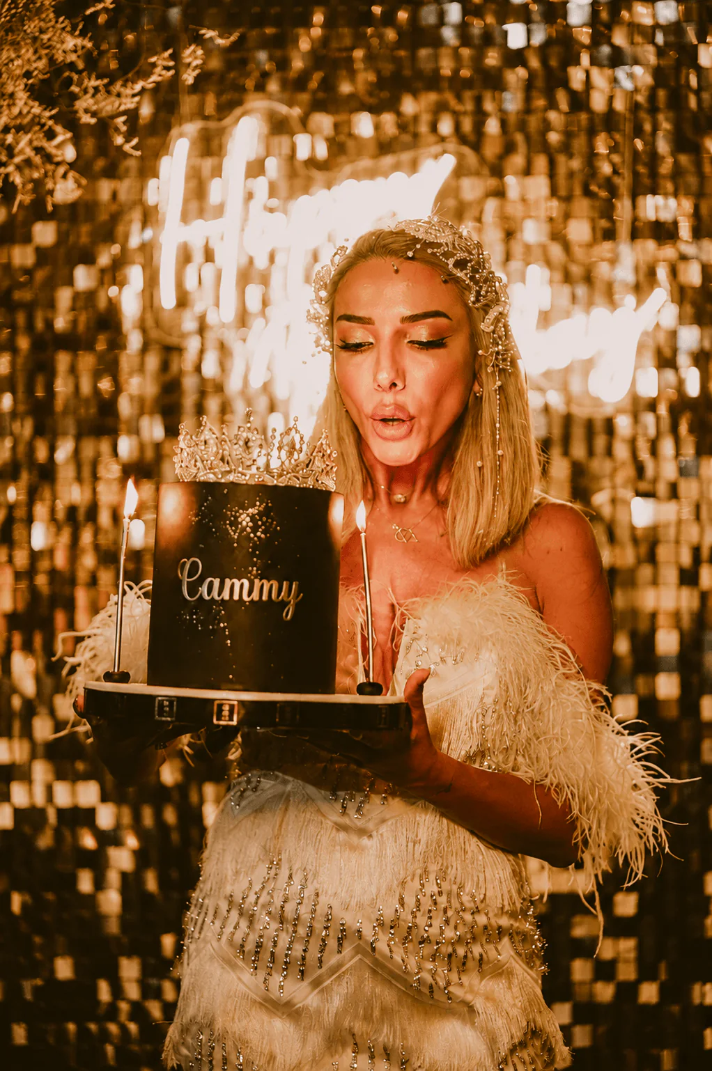 A guest celebrating in front of a shimmering private event backdrop