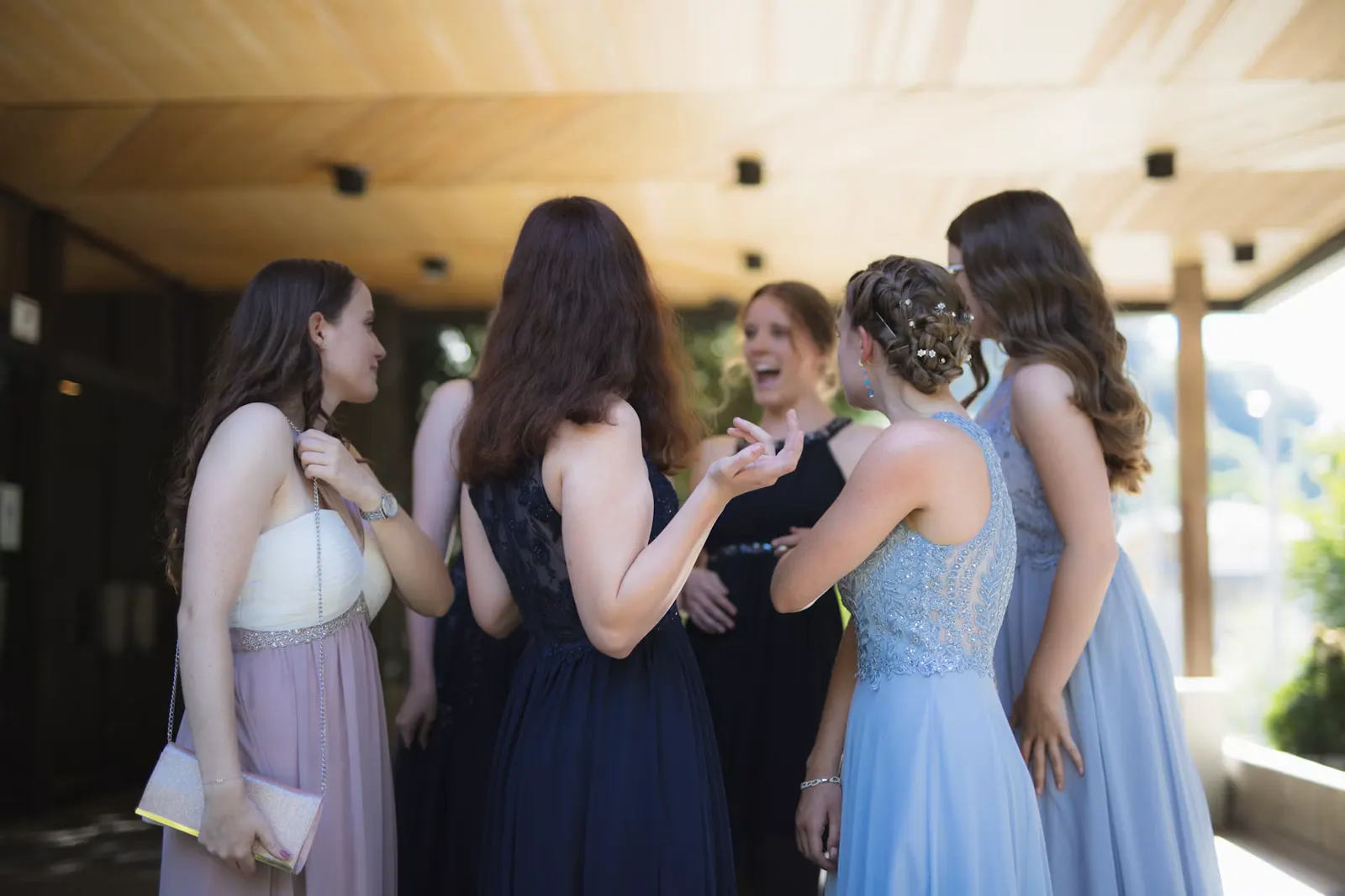 Guests in formal dresses socialising at a school prom and leavers celebration